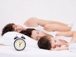 amily sleeping with alarm clock near  their  heads